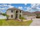 Charming two-story home featuring a three-car garage, landscaped yard, and a welcoming entrance at 18035 Cadence St, Orlando, FL 32820
