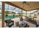A covered patio includes a ceiling fan and seating area for relaxing outdoors with views of the backyard at 18035 Cadence St, Orlando, FL 32820