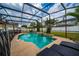 A relaxing screened-in pool has a waterfall feature and tanning ledge, all with relaxing backyard views at 18035 Cadence St, Orlando, FL 32820
