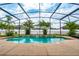 An inviting screened-in pool is surrounded by a sun-soaked patio and is framed by tropical landscaping at 18035 Cadence St, Orlando, FL 32820