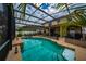 A gorgeous screened-in pool offers clear blue water and backyard views, with mature palms providing privacy at 18035 Cadence St, Orlando, FL 32820