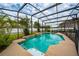 A large screened-in pool with a waterfall feature is surrounded by lush landscaping and a backyard view at 18035 Cadence St, Orlando, FL 32820
