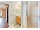 Well-lit bathroom with a single sink vanity, shower, and view into an adjacent room with wood floors at 1960 Jan Lan Blvd, St Cloud, FL 34772