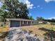 Charming single-story home featuring a gray garage door, brick accents, and a well-maintained lawn at 6025 Se 119Th Pl, Belleview, FL 34420