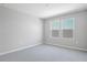 Well-lit, empty bedroom with gray carpet and two bright windows at 1488 August Gray Dr, Kissimmee, FL 34744