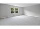 Large carpeted bedroom with ample natural light from two windows overlooking the backyard at 1488 August Gray Dr, Kissimmee, FL 34744