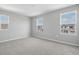 Bright bedroom features plush carpet, soft gray paint, and three windows providing natural light at 1488 August Gray Dr, Kissimmee, FL 34744