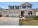 Charming two-story home features a two-car garage, teal shutters and door, and stone accents at 1488 August Gray Dr, Kissimmee, FL 34744