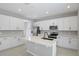 Modern kitchen features white cabinetry, a center island, quartz countertops, and stainless steel appliances at 1488 August Gray Dr, Kissimmee, FL 34744