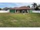 House back view with covered patio and spacious green lawn at 450 Tamarind Parke Ln, Kissimmee, FL 34758