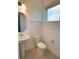 Powder room with pedestal sink, toilet, round mirror, and a window providing ample natural light at 6078 Bimini Twist Loop, Orlando, FL 32819