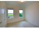 Minimalist bedroom with tile floors, two windows offering natural light, and neutral walls for versatile styling at 6078 Bimini Twist Loop, Orlando, FL 32819