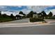 Elegant gated community entrance with lush landscaping, mature palm trees, and paved roads at 6078 Bimini Twist Loop, Orlando, FL 32819