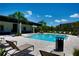 Sparkling community pool with lounge chairs and palm trees under a clear blue sky at 6078 Bimini Twist Loop, Orlando, FL 32819