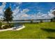 Scenic community view with a lake, lush green lawn, and a relaxing bench under a partly cloudy blue sky at 6078 Bimini Twist Loop, Orlando, FL 32819