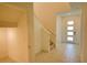 Bright foyer with tiled flooring, staircase, and a contemporary front door, creating an inviting entrance at 6078 Bimini Twist Loop, Orlando, FL 32819