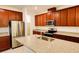 Modern kitchen featuring granite countertops, stainless steel appliances, and wooden cabinetry for a sleek design at 6078 Bimini Twist Loop, Orlando, FL 32819