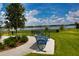 Scenic lake view with inviting park benches, lush greenery, and clear blue skies at 6078 Bimini Twist Loop, Orlando, FL 32819