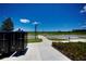 Scenic street view with mailboxes, landscaped sidewalk, and a distant lake for a serene neighborhood ambiance at 6078 Bimini Twist Loop, Orlando, FL 32819