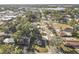 Aerial view showcasing the home's location on a tree-lined street near a lake at 666 Avenue B Sw, Winter Haven, FL 33880