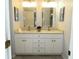Bathroom with double sink vanity, granite countertop, brushed gold faucets, and framed mirrors at 504 Ridge View Dr, Davenport, FL 33837