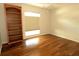 Bedroom with hardwood floors, built in bookcase and window with pleated shades at 504 Ridge View Dr, Davenport, FL 33837
