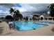 Community pool featuring multiple swimming lanes, lounge seating, and palm trees against a dramatic sky at 504 Ridge View Dr, Davenport, FL 33837