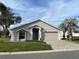 Tan house with a two-car garage and nicely landscaped front yard at 504 Ridge View Dr, Davenport, FL 33837