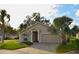 Charming single-story home with a well-manicured lawn, brick driveway, and tropical landscaping in a sunny setting at 504 Ridge View Dr, Davenport, FL 33837