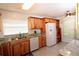 Bright kitchen featuring wood cabinets, granite counters, stainless steel sink, white dishwasher, and refrigerator at 504 Ridge View Dr, Davenport, FL 33837