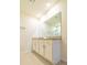Bright bathroom featuring double vanity, granite counters, and large mirror over cream colored cabinets at 527 Noble Ave, Davenport, FL 33837
