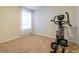 Bright bedroom featuring neutral walls, carpeted flooring and an elliptical exercise machine at 527 Noble Ave, Davenport, FL 33837