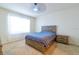Cozy bedroom featuring a wood-frame bed, soft carpet, and a bright window at 527 Noble Ave, Davenport, FL 33837