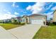 Neat single-story house with vibrant landscaping, a driveway, and an attached two-car garage at 527 Noble Ave, Davenport, FL 33837
