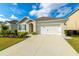 Attractive one-story home featuring tidy landscaping, a driveway, and an attached two-car garage at 527 Noble Ave, Davenport, FL 33837