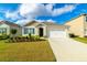 Inviting single-story home featuring a manicured lawn, a driveway, and an attached two-car garage at 527 Noble Ave, Davenport, FL 33837
