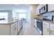 A view of the kitchen including stainless steel appliances, stone countertops and an island at 527 Noble Ave, Davenport, FL 33837