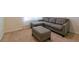 Cozy living room features a sectional sofa, ottoman, carpeted flooring, and lots of natural light at 527 Noble Ave, Davenport, FL 33837