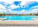 Large community pool with zero entry, splash pad, plenty of seating and blue skies at 527 Noble Ave, Davenport, FL 33837