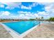 Large community pool with zero entry, splash pad, plenty of seating and blue skies at 527 Noble Ave, Davenport, FL 33837
