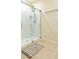 Bright bathroom featuring a shower with glass enclosure and tiled floor with accent rug at 527 Noble Ave, Davenport, FL 33837