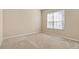 Simple bedroom with neutral walls and carpet flooring, featuring a large window at 9650 Bay Pine Ln, Orlando, FL 32832