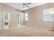 Bright bedroom with carpet flooring, ceiling fan, and ensuite bathroom access at 9650 Bay Pine Ln, Orlando, FL 32832