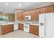 Kitchen boasts wood cabinets, white appliances, and a view to the backyard at 9650 Bay Pine Ln, Orlando, FL 32832