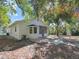 View of the home's backyard featuring the screen patio, brick exterior and mature shade trees at 1234 Lynwood Ave, Apopka, FL 32703