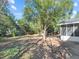 Spacious backyard with mature trees, partial fence, and screened porch at 1234 Lynwood Ave, Apopka, FL 32703