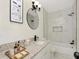 Bathroom with white vanity, granite countertop, stylish mirror, and shower over tub with modern tile at 1234 Lynwood Ave, Apopka, FL 32703