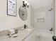 Bathroom with white vanity, granite countertop, stylish mirror, and shower over tub with modern tile at 1234 Lynwood Ave, Apopka, FL 32703