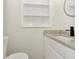 Close-up of bathroom vanity featuring granite countertop and built in shelf at 1234 Lynwood Ave, Apopka, FL 32703