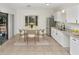 Inviting kitchen features white cabinets, stainless steel appliances, and a cozy breakfast nook by the window at 1234 Lynwood Ave, Apopka, FL 32703